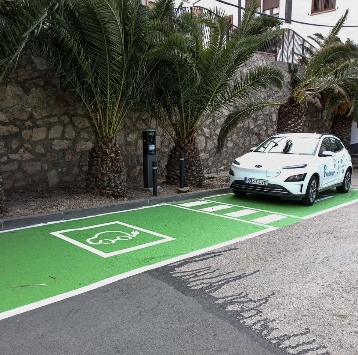 Imagen de un coche con el logo de EVcharge aparcado en una plaza específica para coches electricos